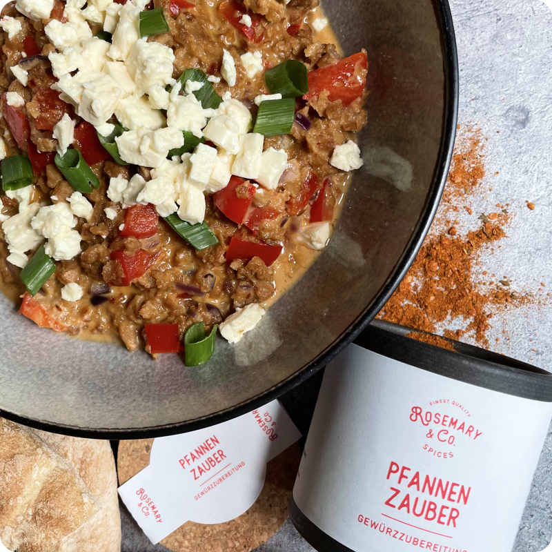 Eine Schüssel mit Hackfleischgericht, Paprika, Frühlingszwiebeln und zerbröckeltem Käse neben einer Pappdose "Pfannen Zauber".