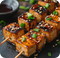 Gegrillte Tofuwürfel auf zwei Spießen