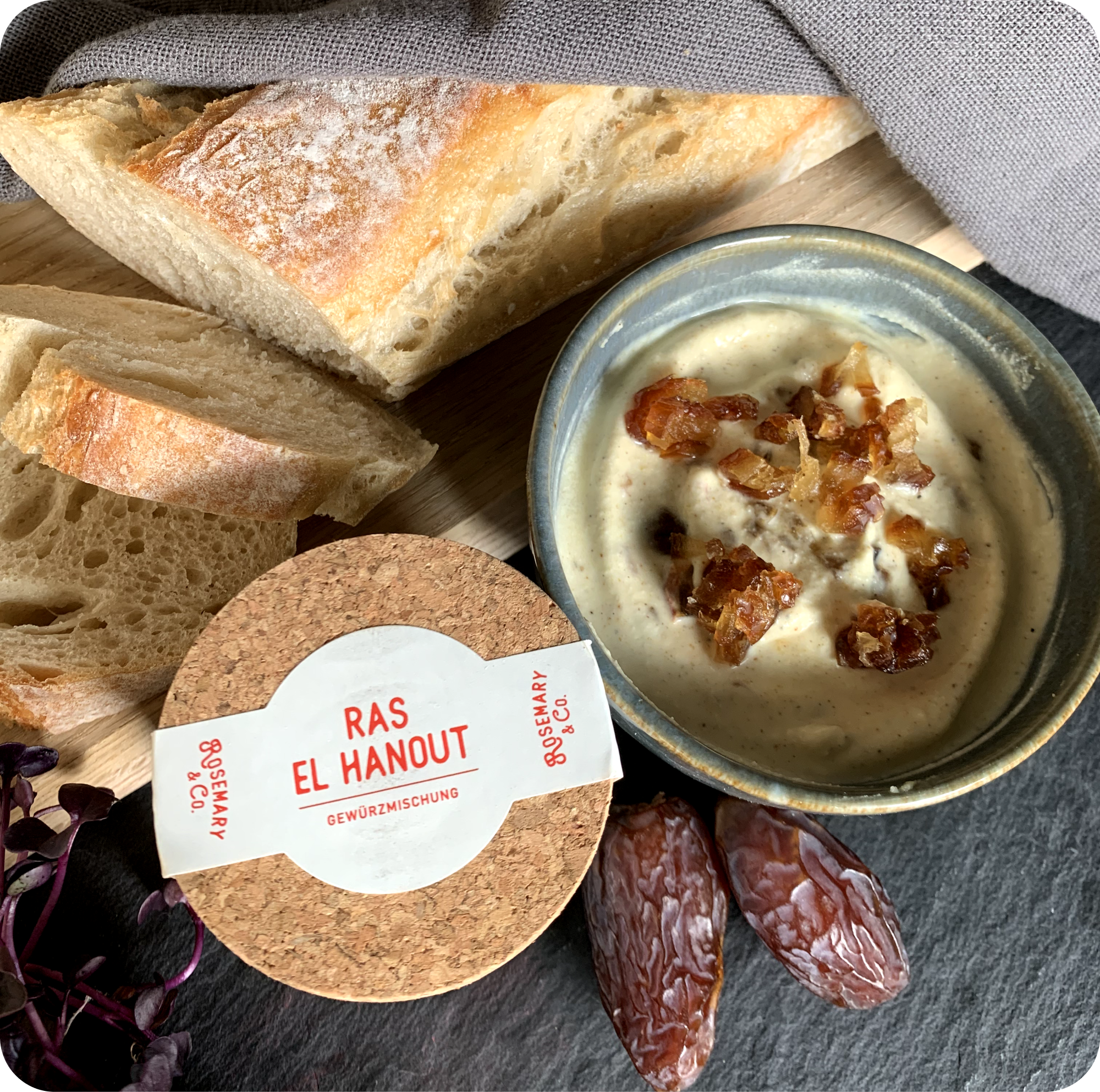 Scheiben Brot, Datteldip in Dose, ganze Datteln, Gewürz Dose Ras el Hanout von Rosemary & Co auf Brett